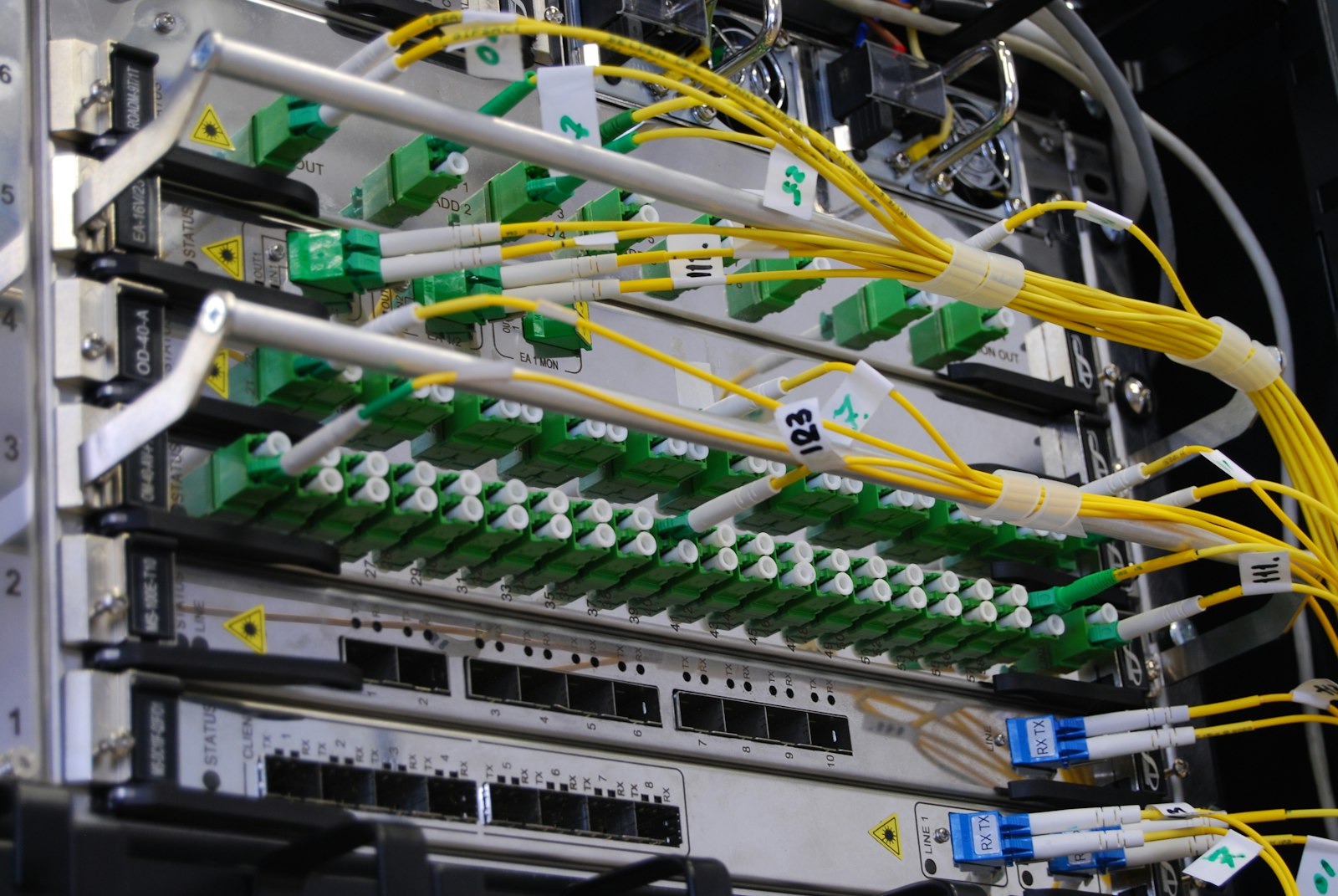 Fibre optic patch panels in a telecoms rack, with yellow fibre leads connected
